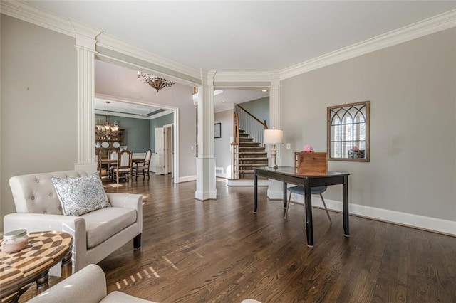 living room with a chandelier, wood finished floors, ornate columns, and ornamental molding