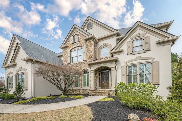 view of front of property featuring stone siding and stucco siding