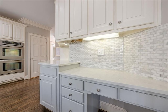 kitchen with tasteful backsplash, stainless steel double oven, dark wood finished floors, and white cabinetry