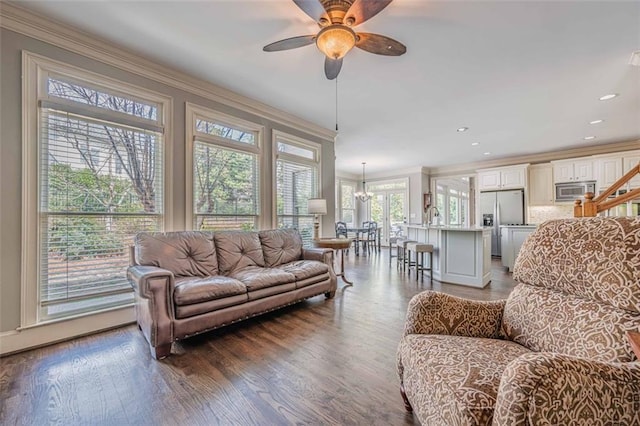 living room featuring recessed lighting, ceiling fan with notable chandelier, crown molding, and wood finished floors