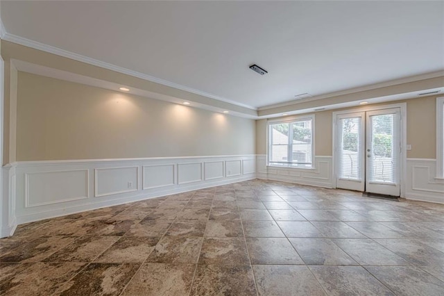 unfurnished room with a decorative wall, a wainscoted wall, french doors, and crown molding