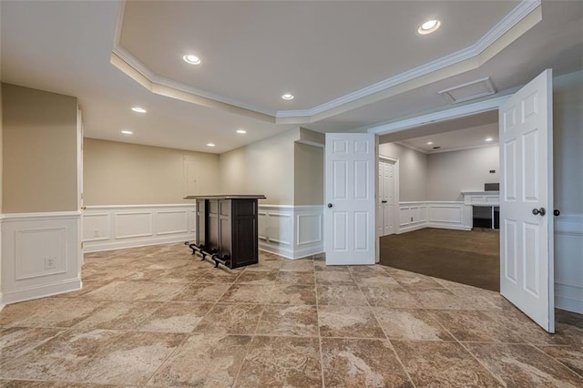 below grade area featuring recessed lighting, ornamental molding, and wainscoting