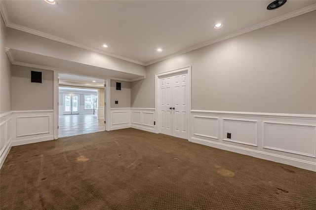 unfurnished room with recessed lighting, a wainscoted wall, ornamental molding, and dark carpet