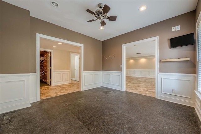 carpeted empty room with a wainscoted wall, recessed lighting, and a ceiling fan