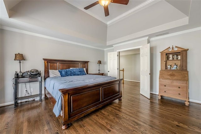 bedroom with visible vents, dark wood-type flooring, and a tray ceiling