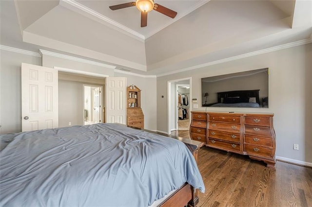 bedroom with baseboards, a raised ceiling, wood finished floors, and ornamental molding