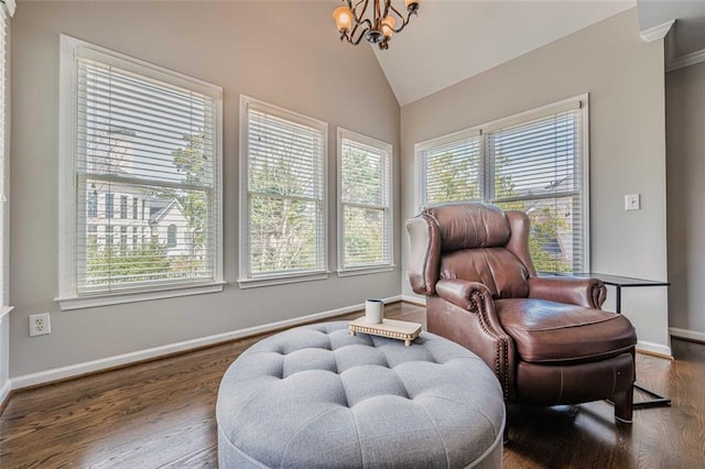 living area with an inviting chandelier, wood finished floors, baseboards, and vaulted ceiling