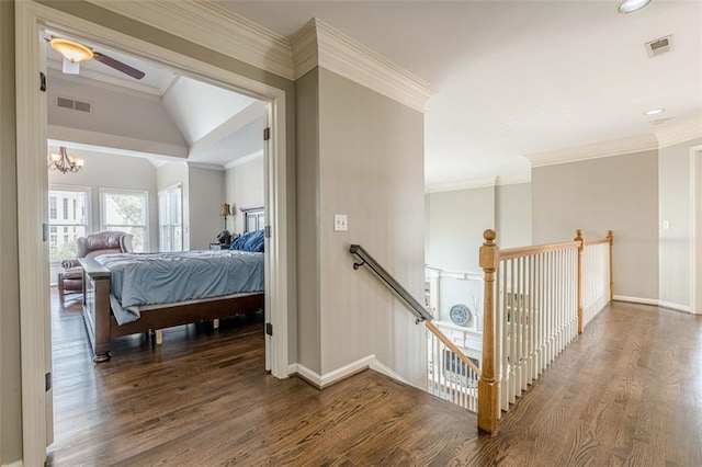 corridor with visible vents, an upstairs landing, wood finished floors, and ornamental molding