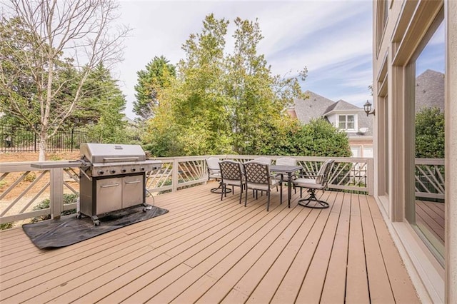 wooden terrace featuring area for grilling and outdoor dining area