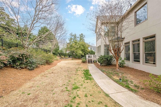 view of yard featuring a deck and fence