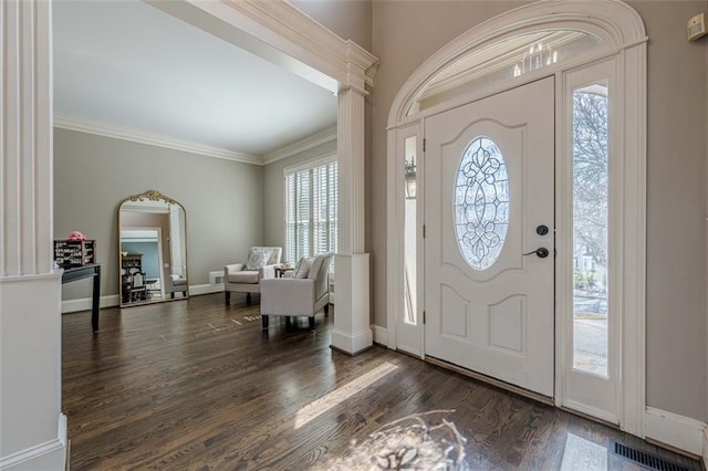 entryway with visible vents, baseboards, decorative columns, ornamental molding, and wood finished floors