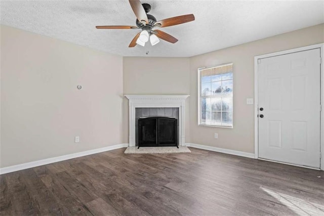 unfurnished living room featuring ceiling fan, dark hardwood / wood-style floors, and a textured ceiling