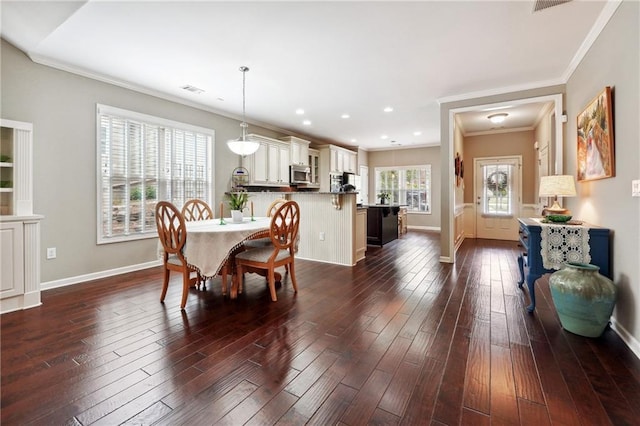 dining room featuring dark wood-type flooring and crown molding