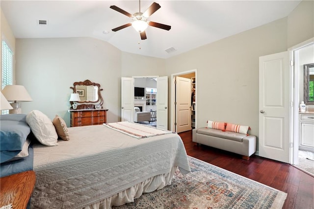 bedroom featuring lofted ceiling, ceiling fan, dark hardwood / wood-style floors, a spacious closet, and a closet