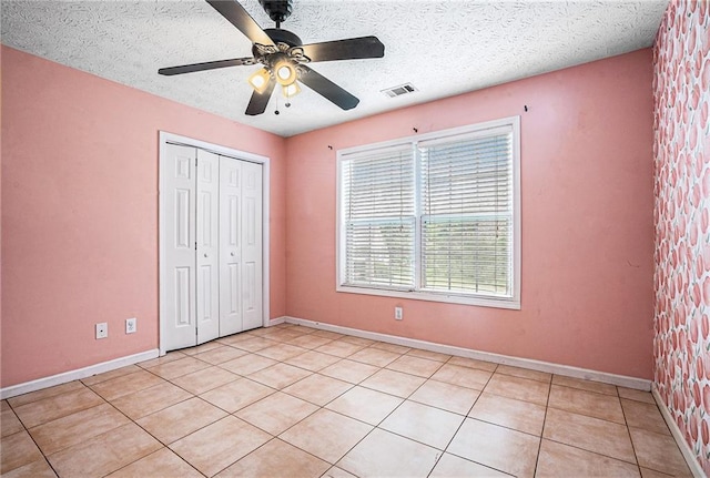 55 Ashland Farm Rd, Oxford, GA 30054 - unfurnished bedroom featuring a closet, light tile patterned floors, a ceiling fan, and a textured ceiling
