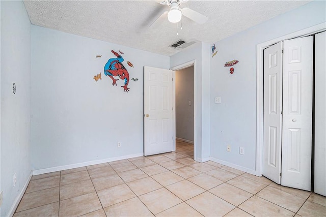 55 Ashland Farm Rd, Oxford, GA 30054 - unfurnished bedroom with a textured ceiling, a closet, light tile patterned floors, and ceiling fan