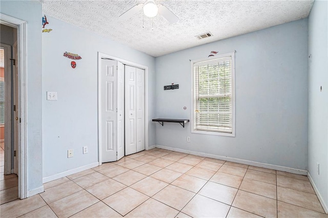 55 Ashland Farm Rd, Oxford, GA 30054 - unfurnished bedroom featuring light tile patterned flooring, a textured ceiling, a closet, and ceiling fan