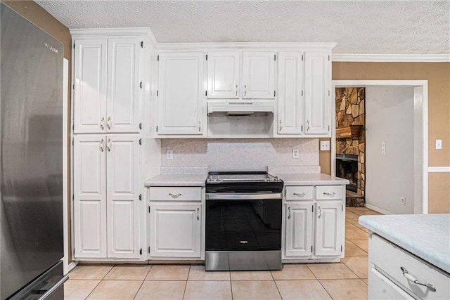 55 Ashland Farm Rd, Oxford, GA 30054 - kitchen with appliances with stainless steel finishes, under cabinet range hood, light countertops, light tile patterned floors, and a textured ceiling