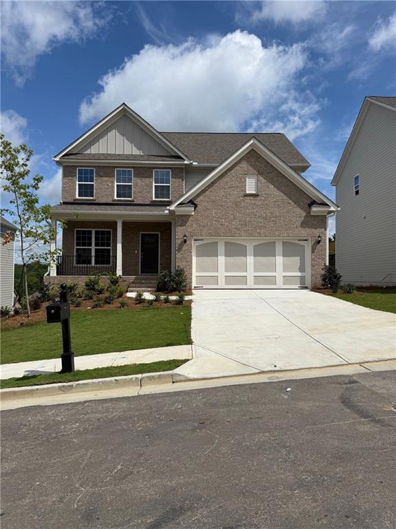 4266 Mulberry Pass Ct, Hoschton, GA 30548 - craftsman inspired home featuring brick siding, driveway, a front lawn, board and batten siding, and covered porch