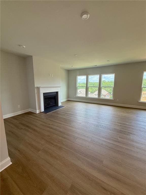 4266 Mulberry Pass Ct, Hoschton, GA 30548 - unfurnished living room featuring plenty of natural light, wood finished floors, and a fireplace
