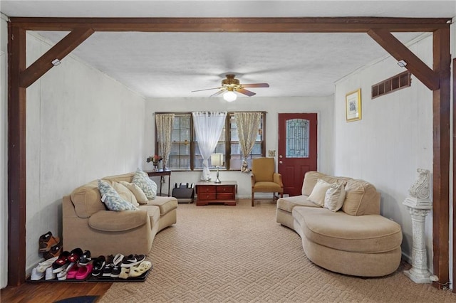 carpeted living room featuring a textured ceiling and ceiling fan