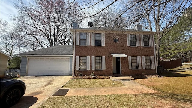 colonial inspired home featuring a front yard, driveway, a chimney, a garage, and brick siding