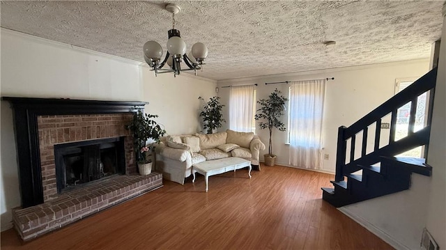 living room with stairs, an inviting chandelier, wood finished floors, and ornamental molding