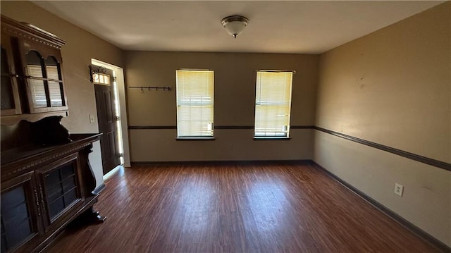 unfurnished room featuring baseboards and wood finished floors