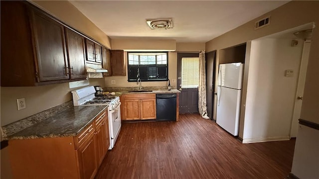 kitchen featuring visible vents, a sink, range hood, white appliances, and dark wood-style flooring