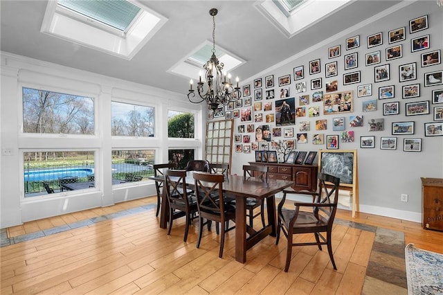 104 Aspen Dr NE, Calhoun, GA 30701 - dining area with a skylight, a chandelier, light wood-style flooring, ornamental molding, and high vaulted ceiling