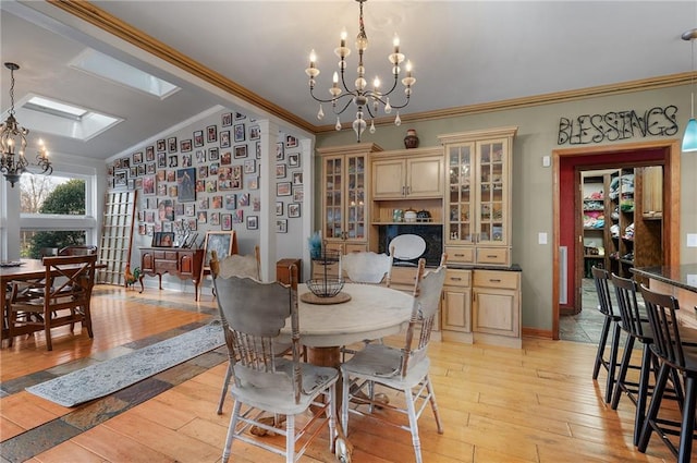 104 Aspen Dr NE, Calhoun, GA 30701 - dining area featuring a chandelier, ornamental molding, light wood-type flooring, vaulted ceiling, and baseboards