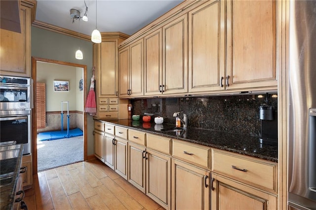 104 Aspen Dr NE, Calhoun, GA 30701 - kitchen featuring light wood-type flooring, appliances with stainless steel finishes, dark stone countertops, a sink, and hanging light fixtures