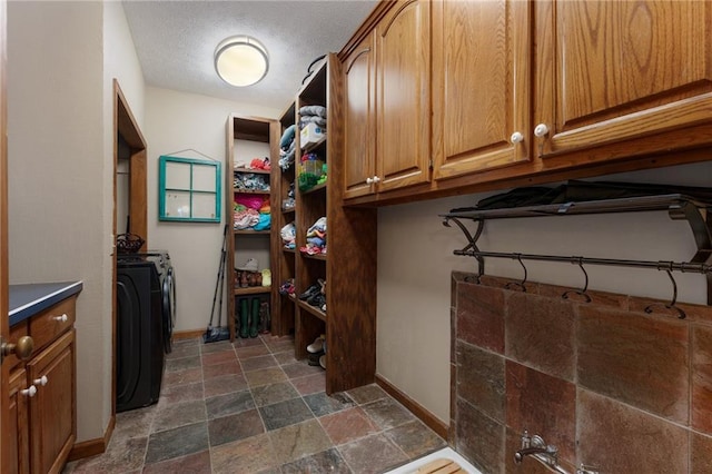 104 Aspen Dr NE, Calhoun, GA 30701 - laundry room featuring stone tile flooring, baseboards, washing machine and dryer, and a textured ceiling