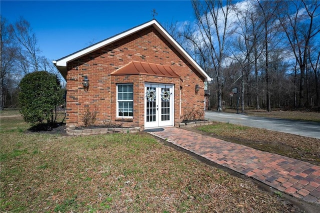 104 Aspen Dr NE, Calhoun, GA 30701 - back of property featuring french doors, brick siding, a yard, and driveway