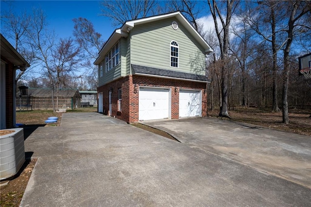 104 Aspen Dr NE, Calhoun, GA 30701 - view of home's exterior with brick siding, driveway, an attached garage, and central AC