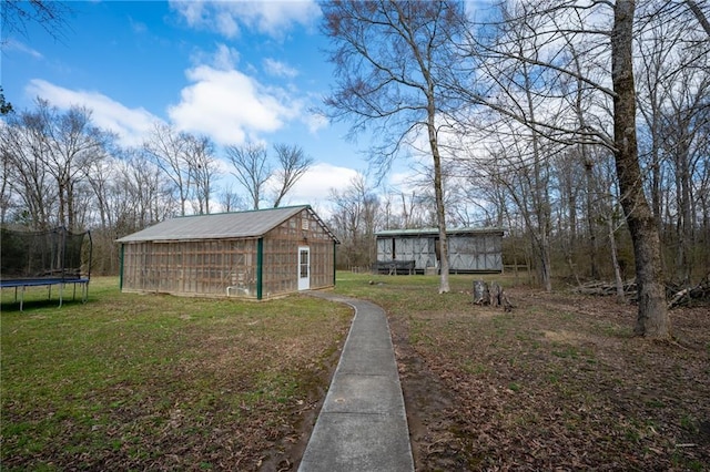 104 Aspen Dr NE, Calhoun, GA 30701 - view of grassy yard featuring an outdoor structure and a trampoline