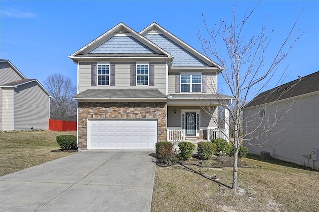 1566 Wilson Manor Cir, Lawrenceville, GA 30045 - craftsman-style home with covered porch, concrete driveway, a garage, stone siding, and a front lawn