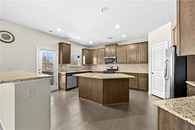 1566 Wilson Manor Cir, Lawrenceville, GA 30045 - kitchen with dark wood-style flooring, visible vents, appliances with stainless steel finishes, backsplash, and a center island