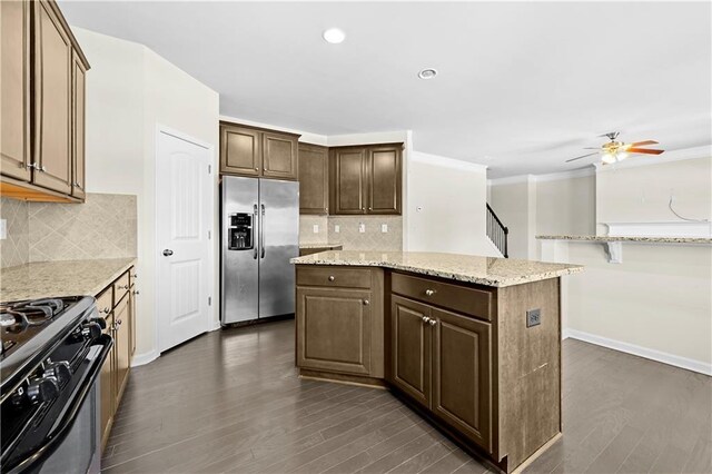 1566 Wilson Manor Cir, Lawrenceville, GA 30045 - kitchen with dark wood-style floors, black range with gas cooktop, a kitchen island, and stainless steel fridge with ice dispenser