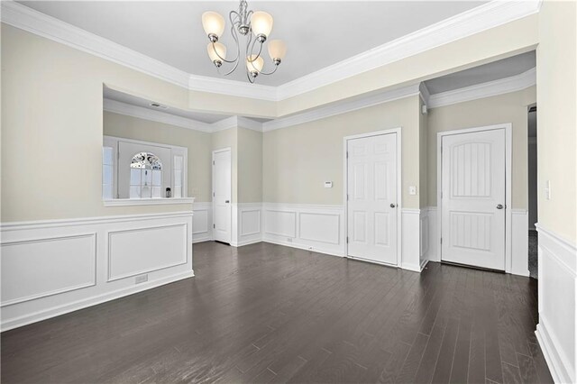1566 Wilson Manor Cir, Lawrenceville, GA 30045 - spare room with a chandelier, dark wood-type flooring, visible vents, ornamental molding, and wainscoting