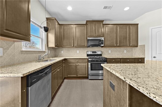 1566 Wilson Manor Cir, Lawrenceville, GA 30045 - kitchen featuring light stone counters, visible vents, decorative backsplash, appliances with stainless steel finishes, and a sink