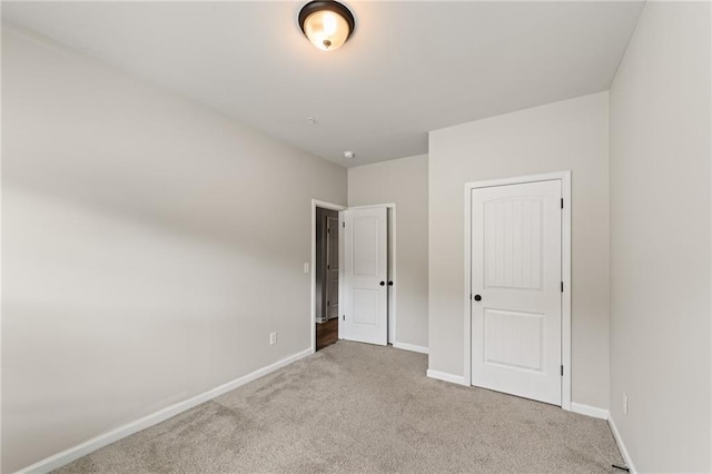 unfurnished bedroom with carpet flooring and baseboards