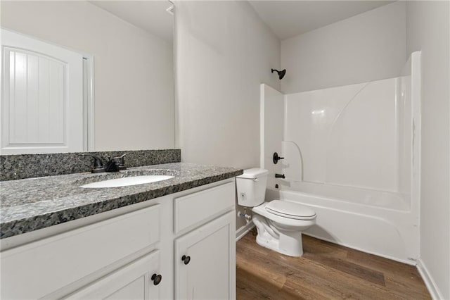 bathroom with vanity, bathing tub / shower combination, wood finished floors, and toilet