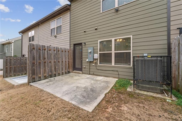 rear view of property featuring a patio area, fence, and cooling unit