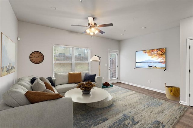 living area with ceiling fan, baseboards, and wood finished floors