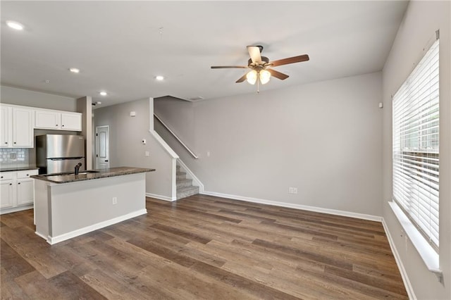 kitchen featuring backsplash, dark wood finished floors, freestanding refrigerator, and white cabinets