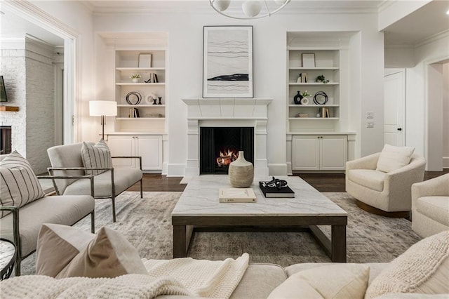 living room with crown molding, dark hardwood / wood-style floors, and built in shelves