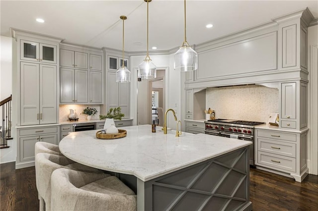 kitchen featuring a spacious island, dark hardwood / wood-style floors, range with two ovens, and backsplash