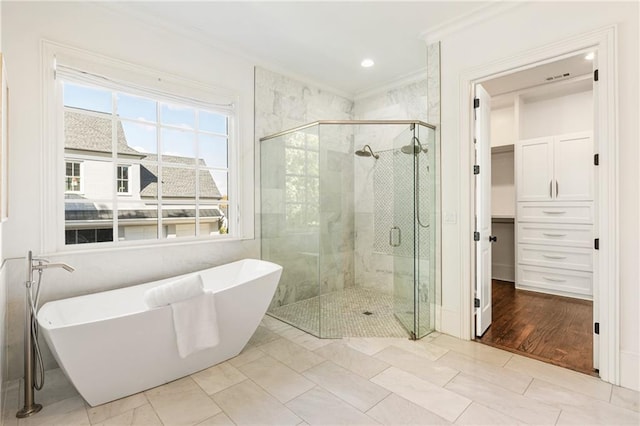 bathroom featuring ornamental molding, hardwood / wood-style floors, and plus walk in shower