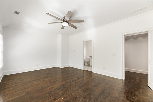 unfurnished bedroom with dark wood-type flooring, crown molding, a closet, and ceiling fan